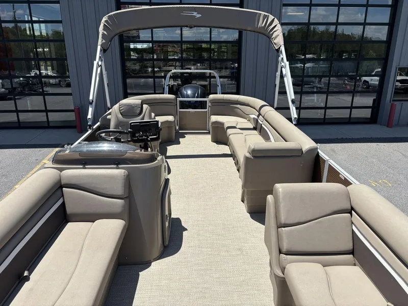 Slide: The Image of 2019 Bennington 23 SSRCX pontoon boat with beige seating and canopy, docked outdoors. - 9