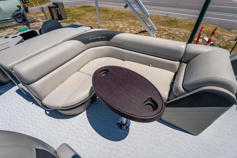 Slide: The Image of 2021 South Bay 224FCR boat interior with beige seating and oval table. - 14