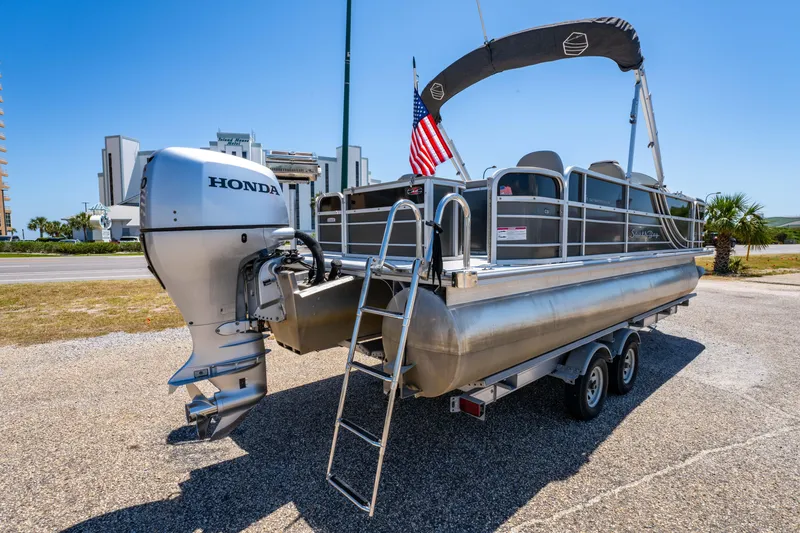 Slide: The Image of 2021 South Bay 224FCR pontoon boat with Honda outboard motor and American flag. - 2