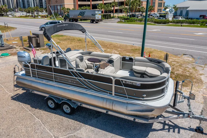 Slide: The Image of 2021 South Bay 224FCR pontoon boat on trailer, parked near a road. - 5