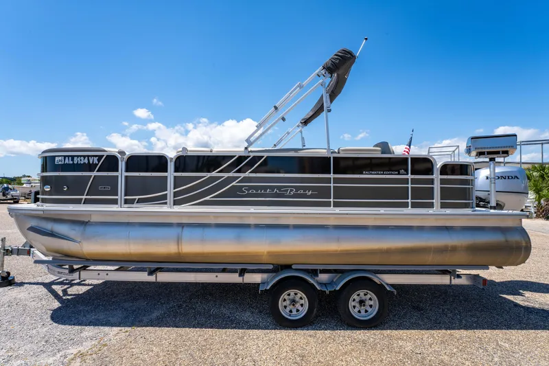 Slide: The Image of 2021 South Bay 224FCR pontoon boat on a trailer under a clear blue sky. - 9