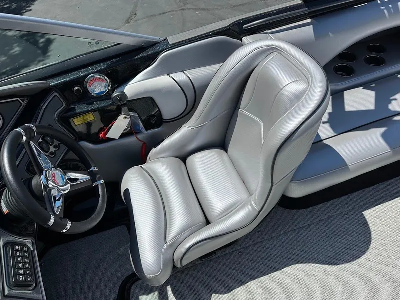 Slide: The Image of 2025 Sanger V215 SX boat interior with sleek gray captain's seat and modern dashboard. - 12