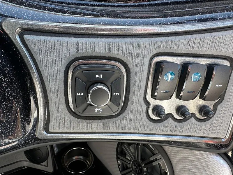 Slide: The Image of Control panel of 2025 Sanger V215 SX boat with audio and switch controls. - 16