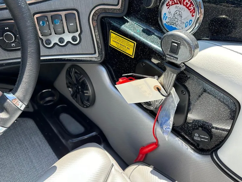 Slide: The Image of 2025 Sanger V215 SX boat dashboard with controls and ignition key. - 17