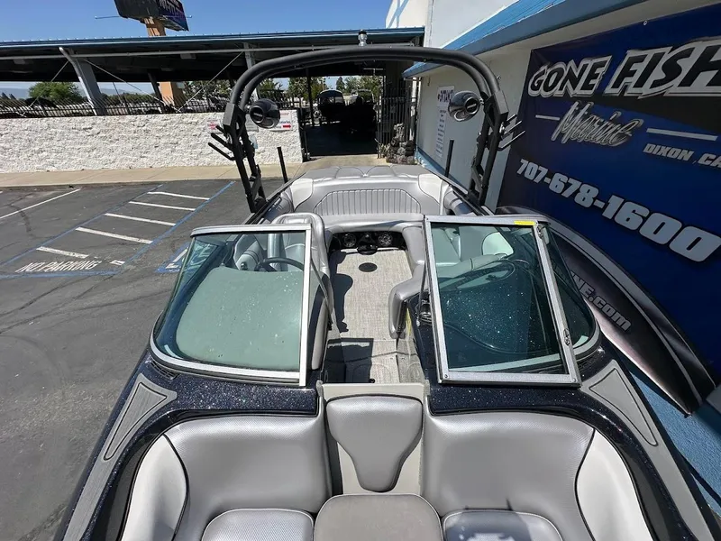 Slide: The Image of 2025 Sanger V215 SX boat interior with open windshield, parked at dealership. - 22