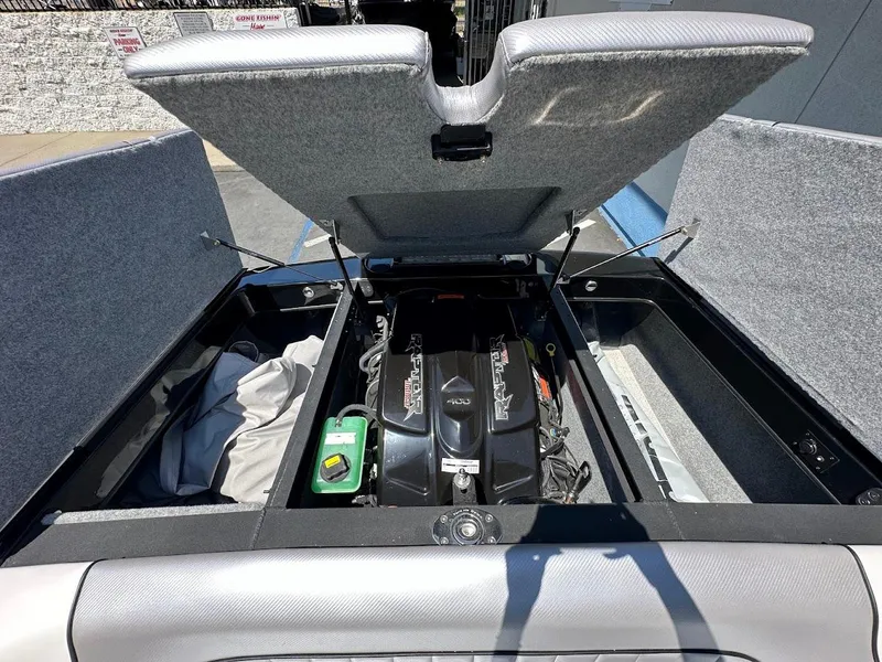 Slide: The Image of 2025 Sanger V215 SX boat engine compartment with open hatch, showcasing engine and storage areas. - 29