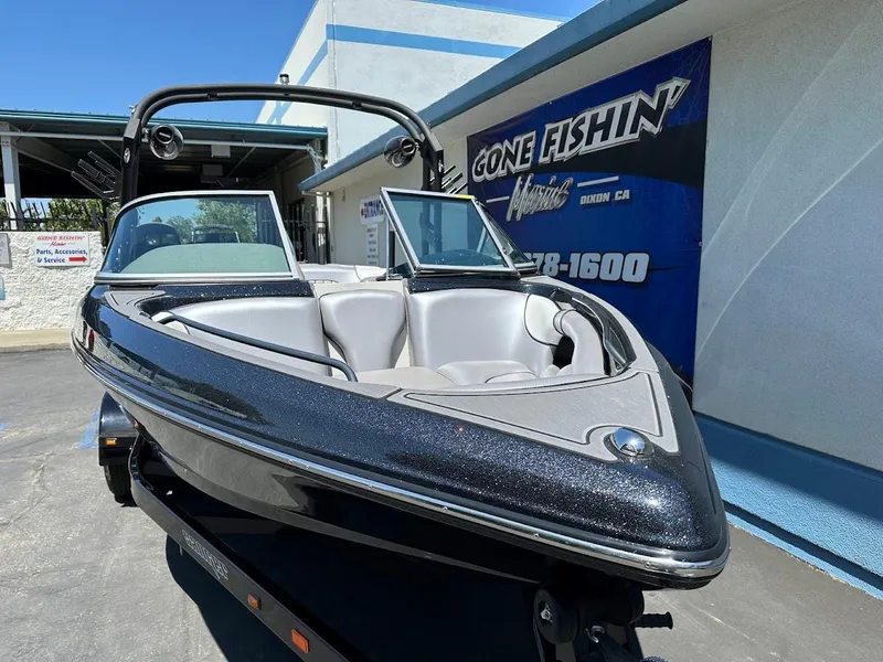 Slide: The Image of 2025 Sanger V215 SX boat displayed outdoors, sleek design, black and silver finish. - 4