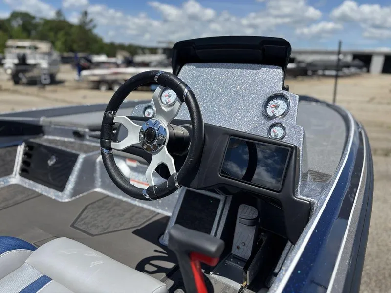 Slide: The Image of 2025 Nitro Z21 XL boat dashboard with steering wheel and gauges, under a clear blue sky. - 8
