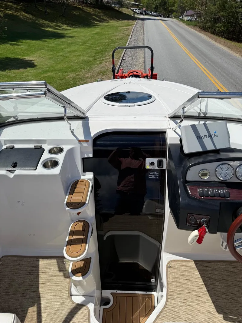Slide: The Image of 2008 Regal 2750 boat interior with dashboard, steering wheel, and steps, parked on roadside. - 19