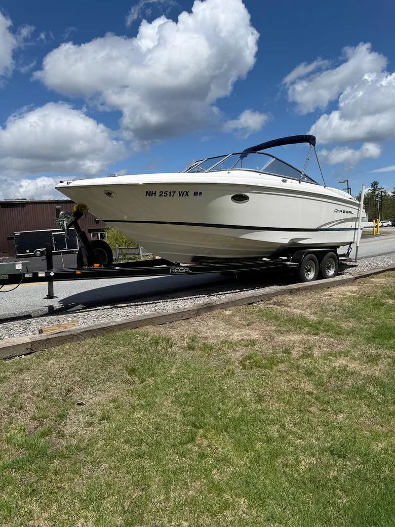 Slide: The Image of 2008 Regal 2750 boat on trailer under a blue sky with clouds. - 2