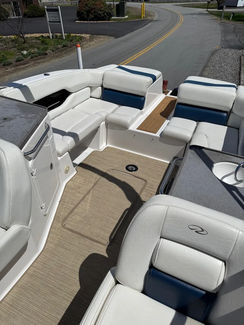 Slide: The Image of 2008 Regal 2750 boat interior with white and blue seating, beige carpet, and open layout. - 27