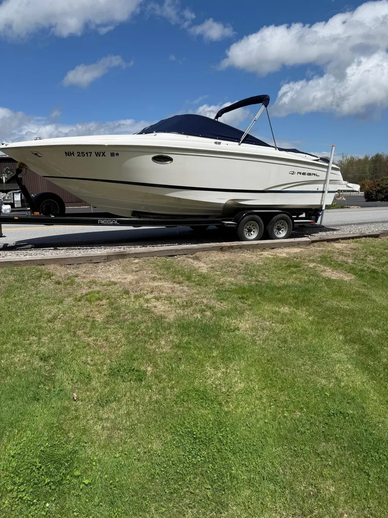 Slide: The Image of 2008 Regal 2750 boat on trailer, parked on grass under blue sky. - 4