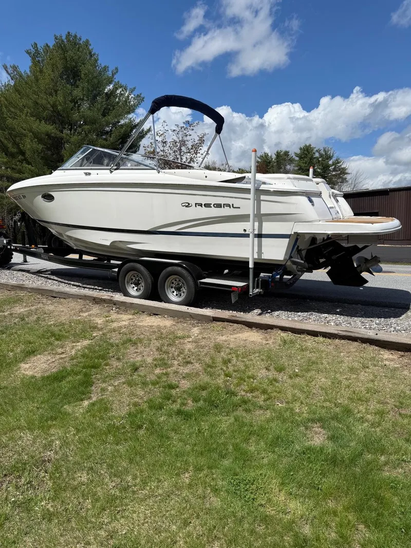 Slide: The Image of 2008 Regal 2750 boat on trailer, parked outdoors under a blue sky. - 9