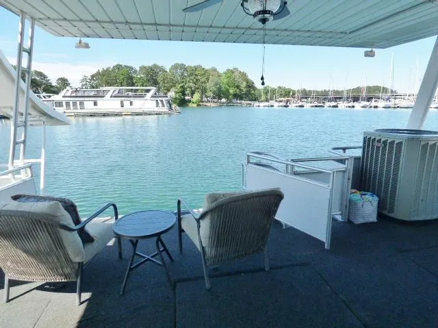 Slide: The Image of 2001 Sumerset 20x103 houseboat deck with chairs, table, and scenic lake view. - 14