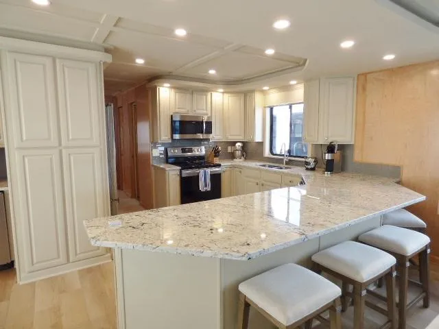 Slide: The Image of Luxurious kitchen in 2001 Sumerset 20x103 houseboat with granite countertops and modern appliances. - 4