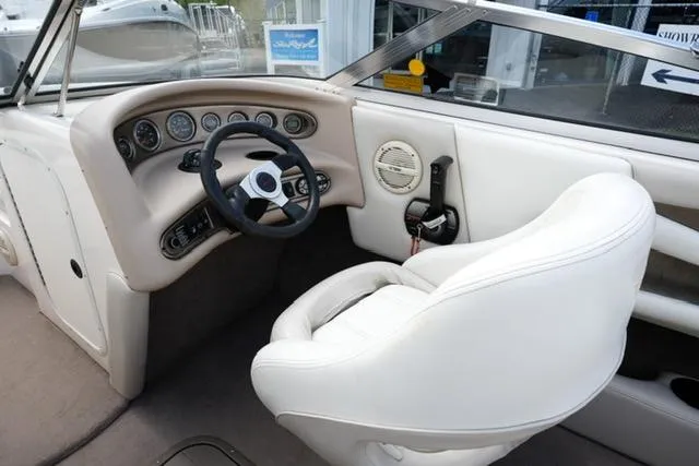 Slide: The Image of Interior of a 2004 Bryant 200 boat with white seating and dashboard controls. - 10
