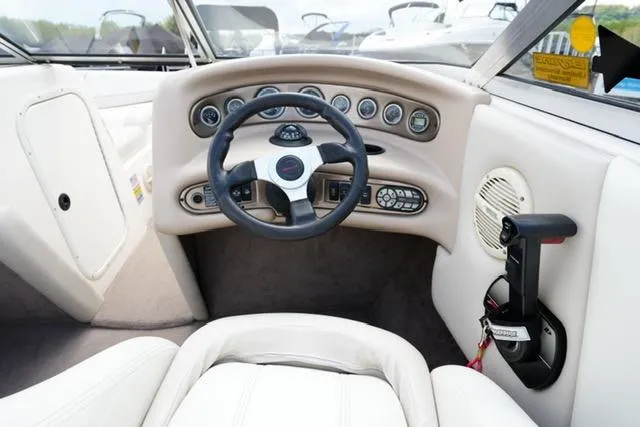 Slide: The Image of Interior of a 2004 Bryant 200 boat, featuring steering wheel and control panel. - 11