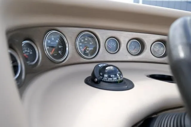 Slide: The Image of Dashboard of a 2004 Bryant 200 boat with gauges and compass. - 12