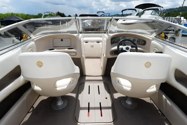 Slide: The Image of Interior of a 2004 Bryant 200 boat with dual white seats and dashboard. - 13