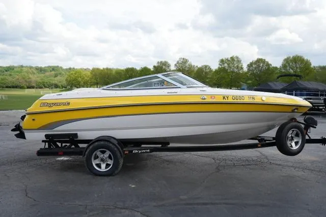 Slide: The Image of 2004 Bryant 200 boat with yellow and white design on a trailer. - 3