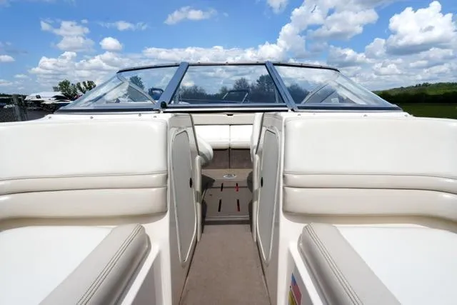 Slide: The Image of 2004 Bryant 200 boat interior with white seating and clear skies. - 9