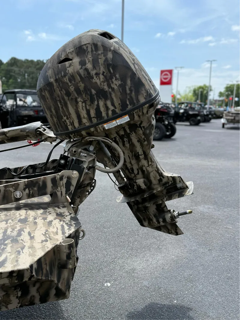 Slide: The Image of Camouflage-patterned outboard motor on 2025 Excel 1651 Viper F4 boat, parked outdoors. - 7