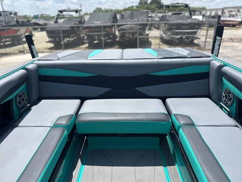 Slide: The Image of 2023 Axis A225 boat interior with teal and gray seating, outdoor setting. - 3