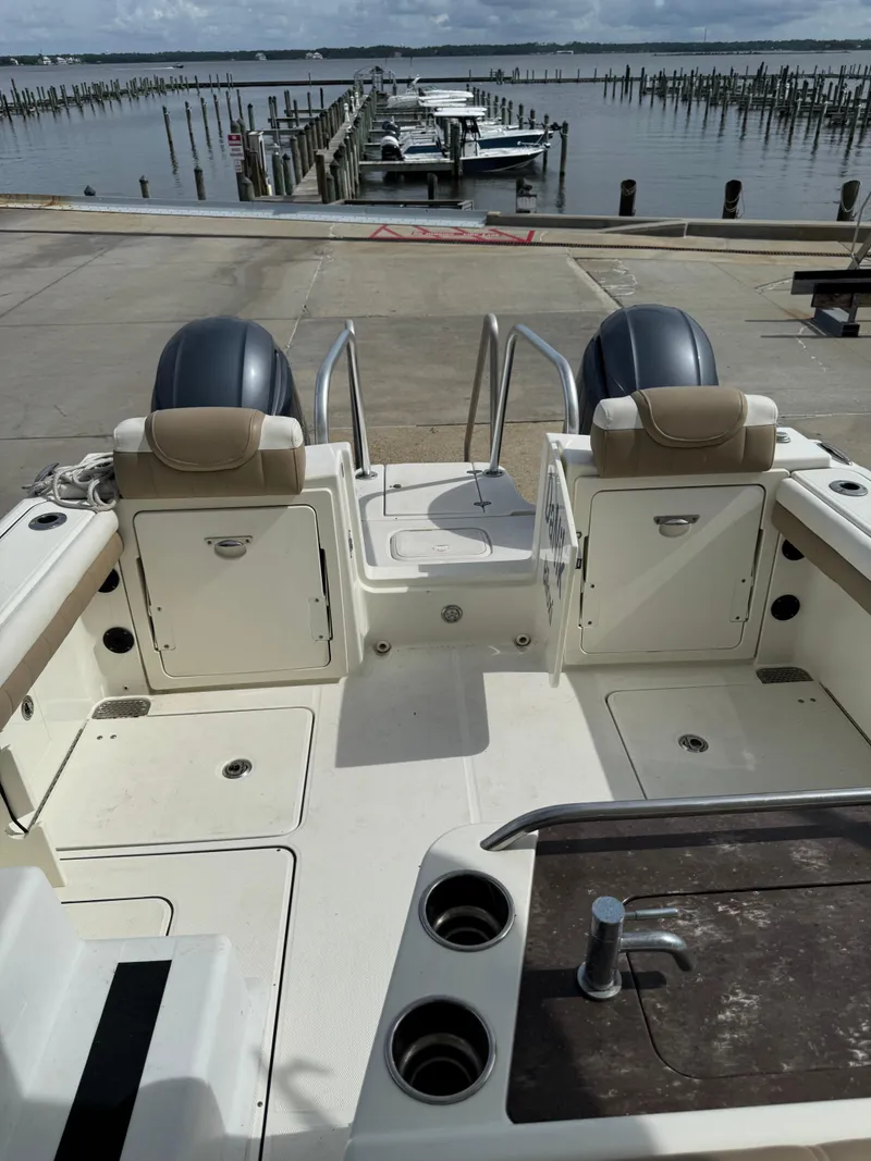Slide: The Image of 2018 World Cat Glacier Bay Edition 2740 Dual Console at dock, showcasing spacious deck and seating. - 14