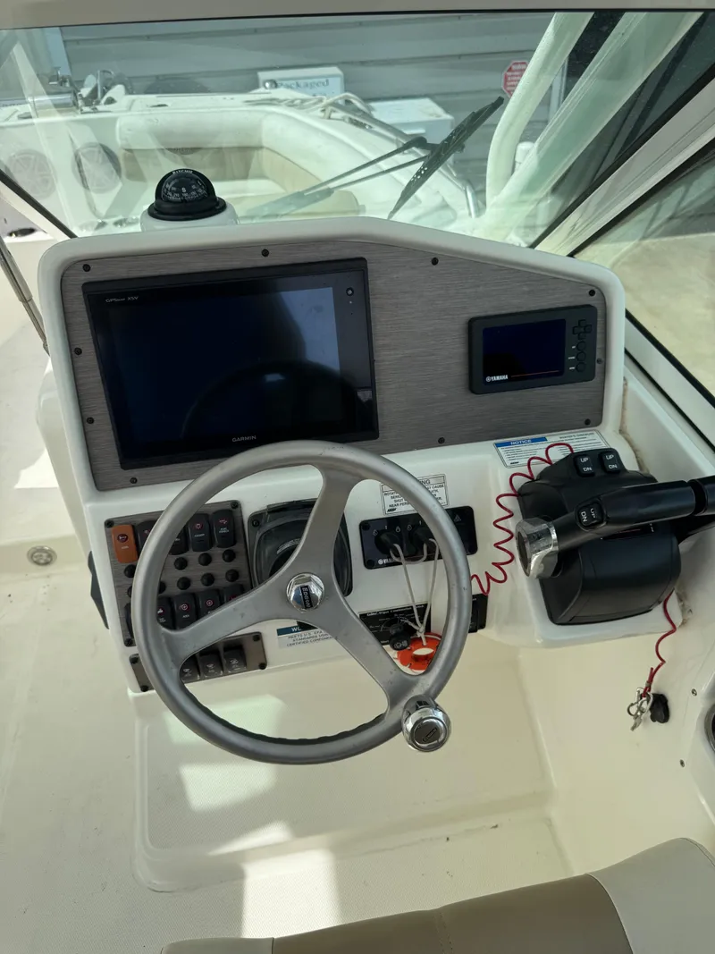 Slide: The Image of 2018 World Cat Glacier Bay Edition 2740 Dual Console helm with steering wheel and navigation controls. - 15