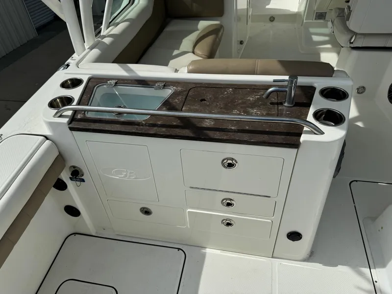 Slide: The Image of 2018 World Cat Glacier Bay Edition 2740 Dual Console boat interior with sink and storage. - 4