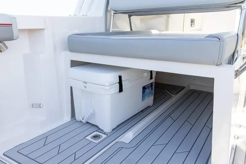 Slide: The Image of 2025 Solara S-250 DC boat interior with storage compartment and cooler under cushioned seat. - 13