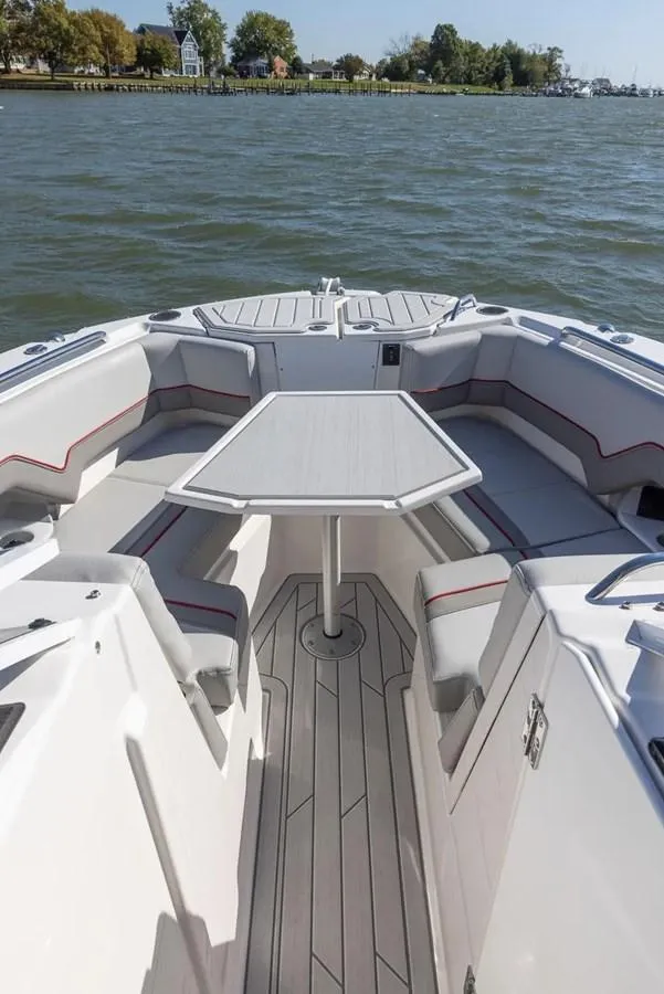 Slide: The Image of 2025 Solara S-250 DC boat interior with seating and table on a calm lake. - 21