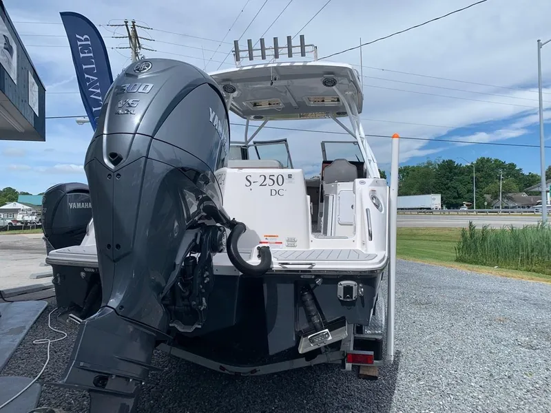 Slide: The Image of 2025 Solara S-250 DC boat with Yamaha engine, parked outdoors on gravel. - 4