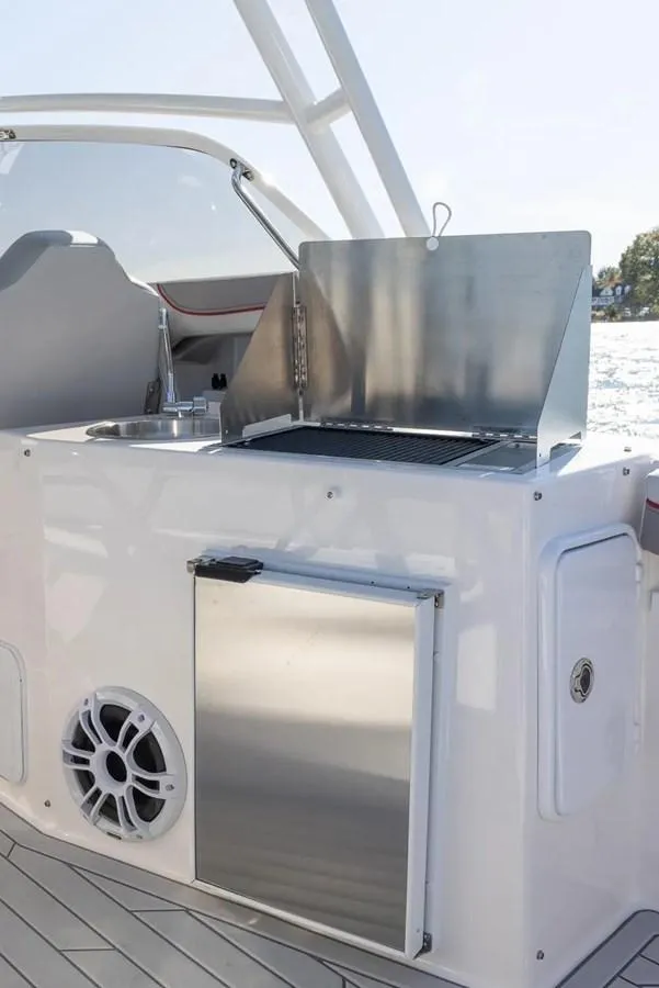 Slide: The Image of 2025 Solara S-250 DC boat with onboard grill and sink, docked by the water. - 8