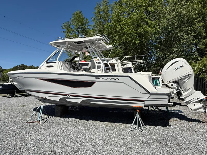 Slide: The Image of 2025 Solara S-250 CW boat on stands, featuring Yamaha outboard motor, parked on gravel. - 2