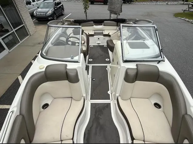 Slide: The Image of 2012 Yamaha Boats 242 Limited interior with beige seating and open windshield. - 6