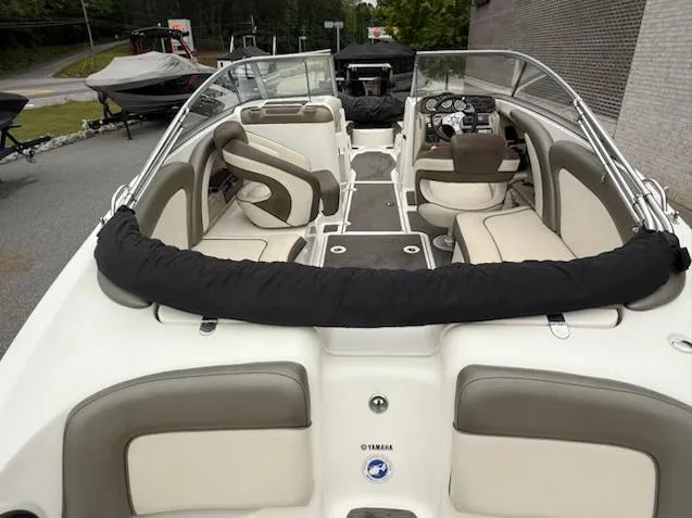 Slide: The Image of 2012 Yamaha Boats 242 Limited interior with beige seating and sleek dashboard. - 7