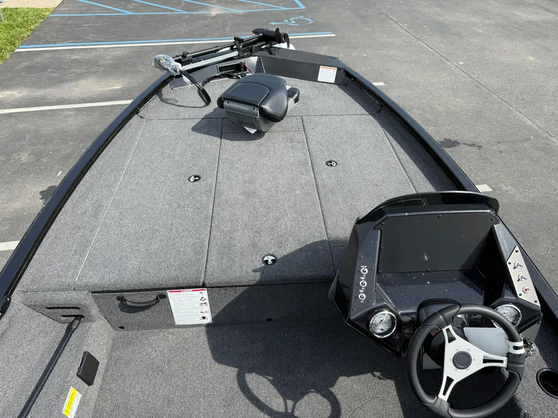 Slide: The Image of 2024 Crestliner XF 189 boat interior with steering wheel and seating on a paved surface. - 3