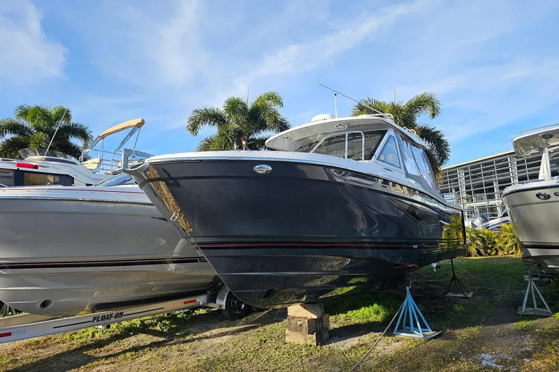 The Image of 2025 Solara S-310 CW boat displayed outdoors with palm trees and blue sky. - 0
