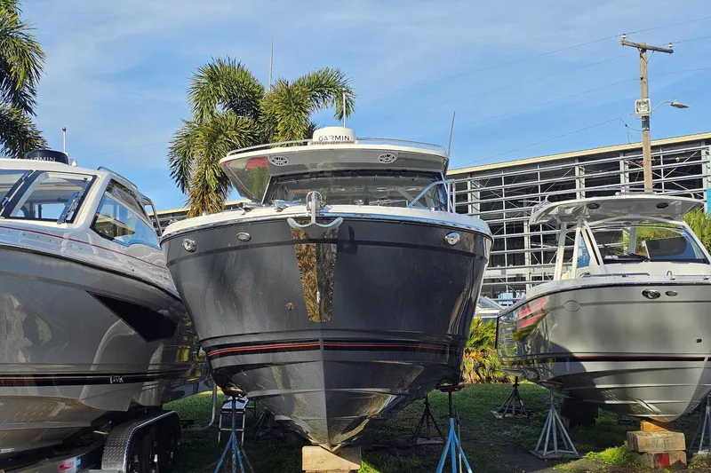 Slide: The Image of 2025 Solara S-310 CW boat displayed outdoors with palm trees and clear sky. - 1