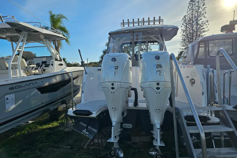 Slide: The Image of 2025 Solara S-310 CW boat with dual 300 V6 engines, docked outdoors. - 3