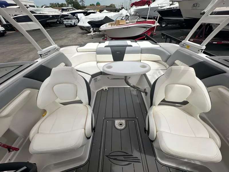 Slide: The Image of 2023 Chaparral 23 SSi boat interior with white seating and a central table. - 2