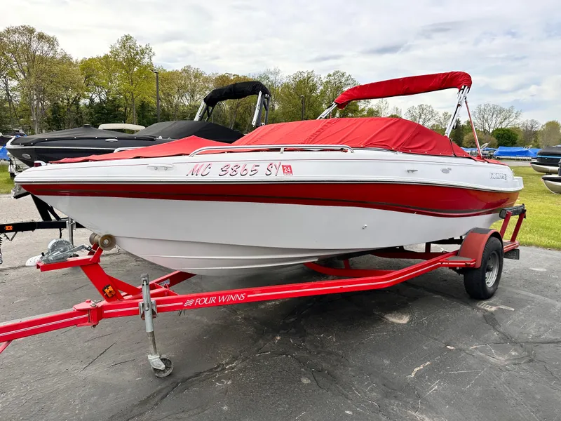 Slide: The Image of 2004 Four Winns 200 Horizon Open Bow boat on red trailer, parked outdoors. - 3