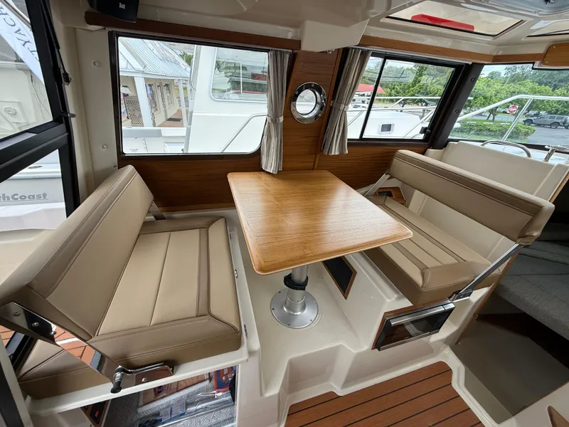 Slide: The Image of Interior of 2025 Ranger Tugs R-23 boat with seating and wooden table. - 10