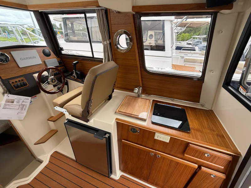 Slide: The Image of Interior of 2025 Ranger Tugs R-23 boat with wood finish and modern amenities. - 11