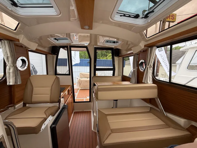 Slide: The Image of Interior of 2025 Ranger Tugs R-23 boat with modern seating and wood accents. - 14