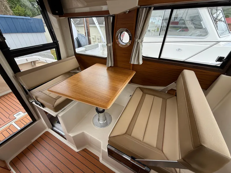 Slide: The Image of Interior of 2025 Ranger Tugs R-23, featuring a cozy dining area with wood accents. - 17
