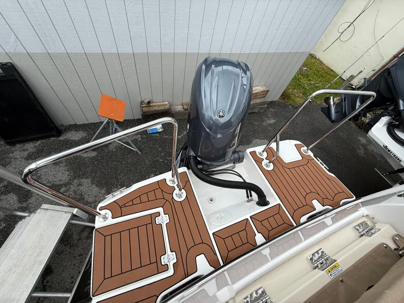 Slide: The Image of 2025 Ranger Tugs R-23 boat stern with outboard motor and teak-style decking. - 4