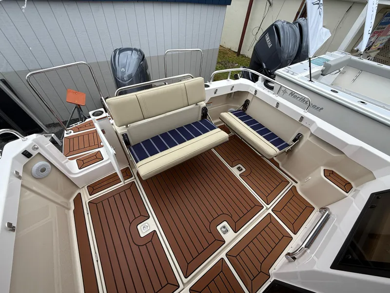 Slide: The Image of 2025 Ranger Tugs R-23 boat deck with cushioned seating and wood-style flooring. - 7