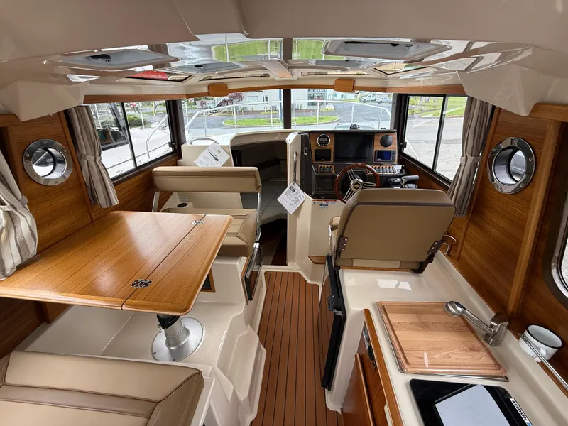 Slide: The Image of Interior of 2025 Ranger Tugs R-25 boat, featuring wood accents and modern amenities. - 10